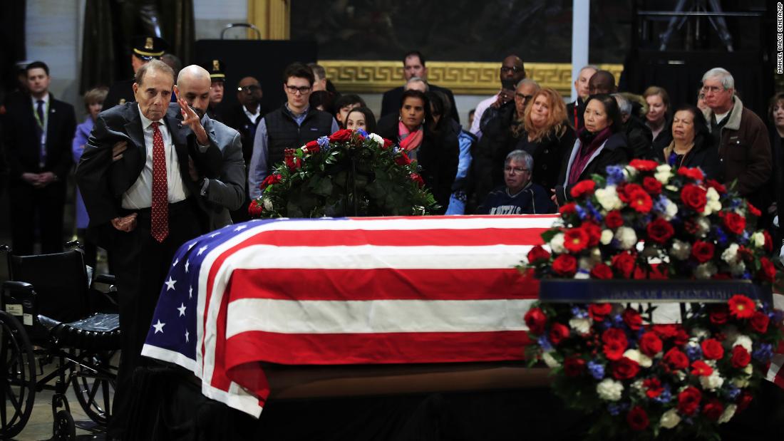 Dole salutes the flag-draped casket of former President George H.W. Bush at the US Capitol in 2018.