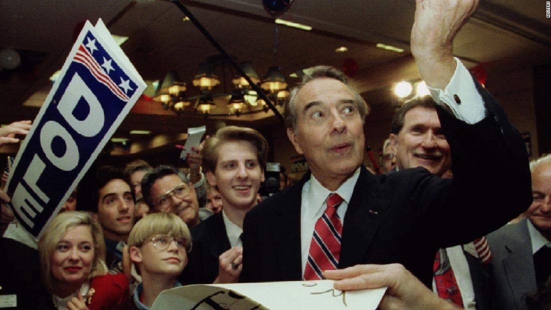 Dole takes a look at a $100 bill a supporter wanted signed at a campaign rally in Jacksonville, Florida, in 1996.