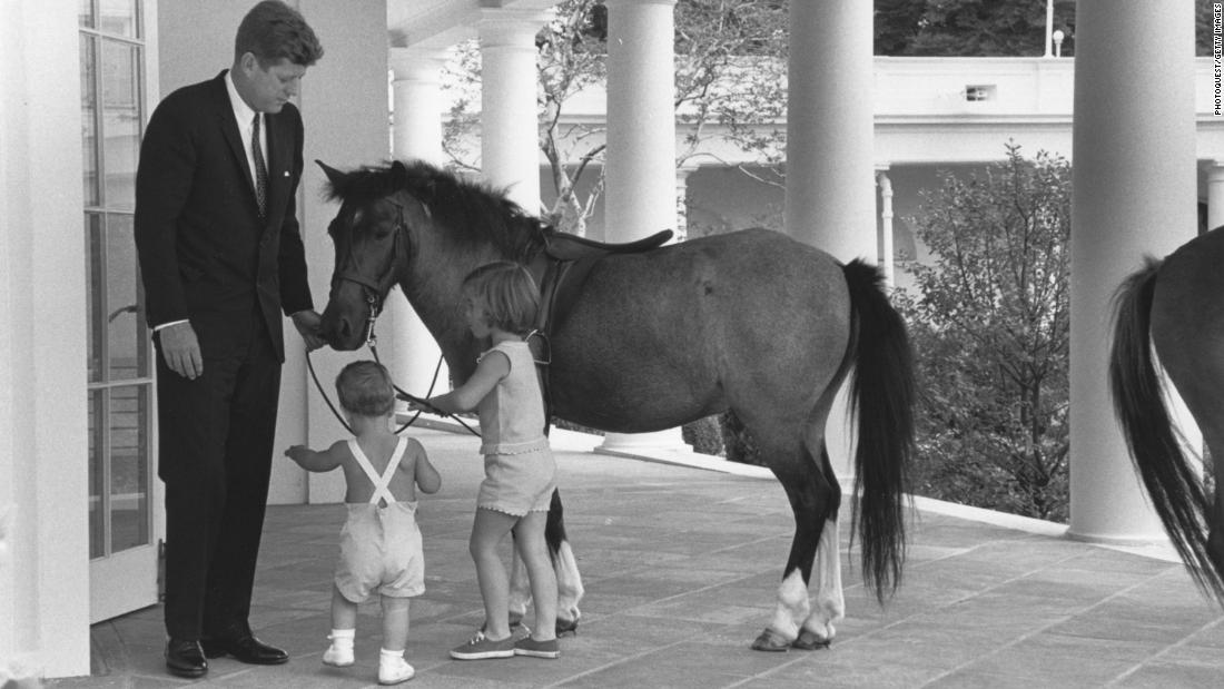 John F. Kennedy and his children John and Caroline play with their pony Macaroni in 1962.