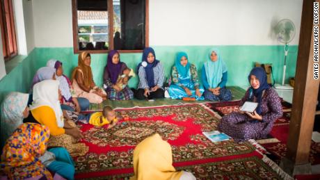 Ibu Suparti  demonstrates the tablet to other women at a community center in Dompyongan, Klaten, Indonesia, in 2017.