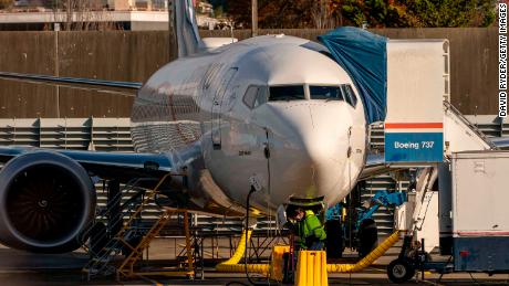 RENTON, WA - NOVEMBER 13: A worker stands under a Boeing 737 Max airplane as it sits parked at the company&#39;s Renton production facility on November 13, 2020 in Renton, Washington. Boeing has announced new cancellations of orders of the plane as it readies for approval to fly it again. (Photo by David Ryder/Getty Images)