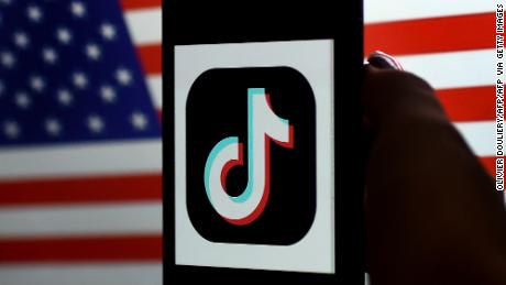 In this photo illustration, the social media application logo, TikTok is displayed on the screen of an iPhone on an American flag background on August 3, 2020 in Arlington, Virginia. - President Donald Trump said Monday that Chinese-owned hugely popular video-sharing app TikTok will be &quot;out of business&quot; in the United States if not sold to a US firm by September 15, 2020.&quot;I set a date of around September 15, at which point it&#39;s going to be out of business in the United States,&quot; he told reporters. (Photo by Olivier DOULIERY / AFP) (Photo by OLIVIER DOULIERY/AFP via Getty Images)