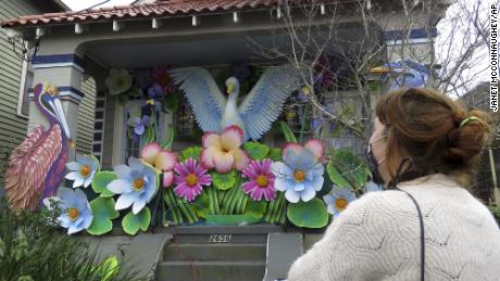 Designer Caroline Thomas looks at a house decorated like a parade float.