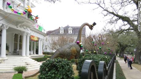 Passers-by look at dinosaur figures at a mansion in St. Louis.  Charles Avenue.