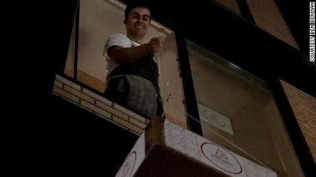 Ben Berman lowers the pizzas to lucky recipients from his second-floor window.