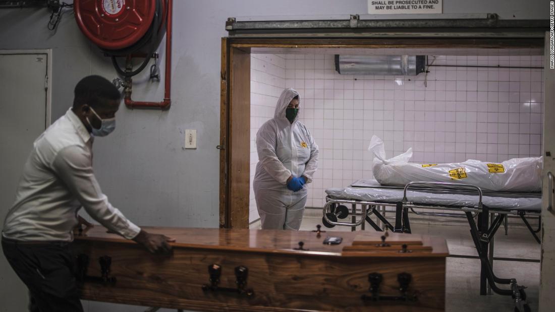 A morgue attendant, right, stands next to the body of a Covid-19 victim in Pretoria, South Africa, on January 22.