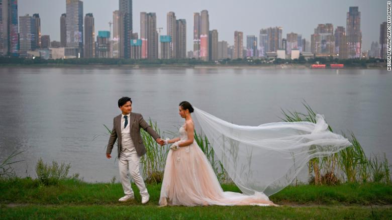 Пара позирует во время свадебной фотосессии рядом с рекой Янцзы в Ухане, Китай.