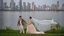 A couple poses during a wedding photo shoot next to Yangtze River in Wuhan, China.