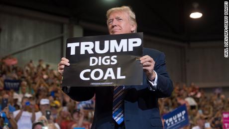 US President Donald Trump holds up a &quot;Trump Digs Coal&quot; sign as he arrives to speak during a Make America Great Again Rally at Big Sandy Superstore Arena in Huntington, West Virginia, August 3, 2017. (Photo by SAUL LOEB / AFP) (Photo by SAUL LOEB/AFP via Getty Images)