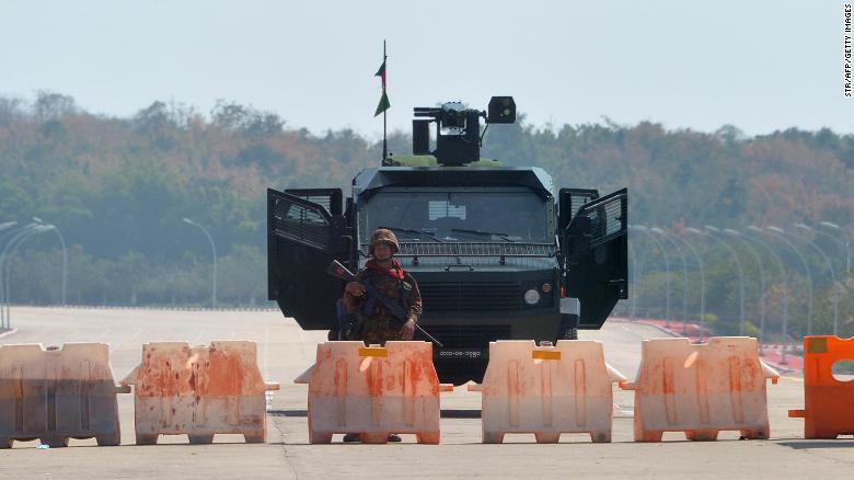 A soldier stands guard on a blockaded road to Myanmar&#39;s parliament in Naypyidaw on February 1, 2021, after the military detained the country&#39;s de facto leader Aung San Suu Kyi and the country&#39;s president in a coup. 
