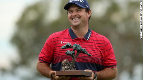 Reed celebrates with the trophy after winning the Farmers Insurance Open.