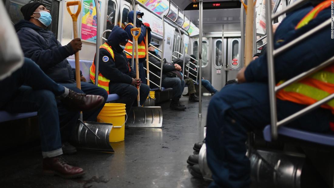 Workers hold snow shovels on the New York subway.