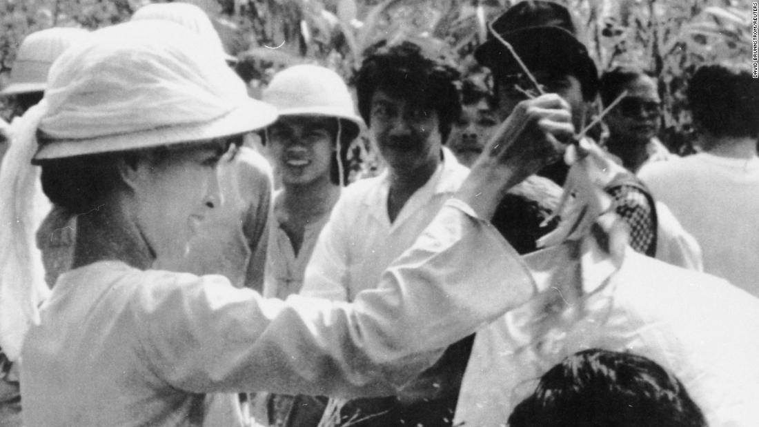 Suu Kyi sprinkles water over the heads of her followers during a traditional new year ceremony in Yangon in 1989. Five days of celebrations were marked by anti-government protests closely watched by armed troops.