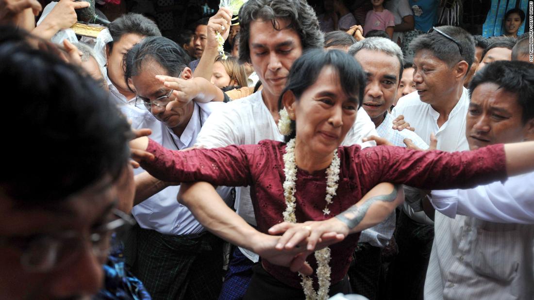 Suu Kyi is held by her son Kim Aris as she is greeted by supporters during a visit to the ancient temple city of Bagan in 2011.