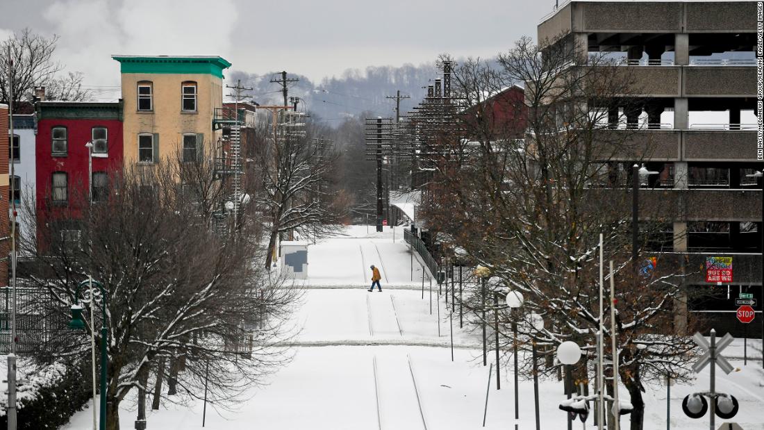 A person crosses snowy railroad tracks in Reading, Pennsylvania, on Monday.