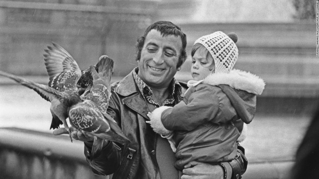 Bennett feeds pigeons with his daughter Joanna in 1972.