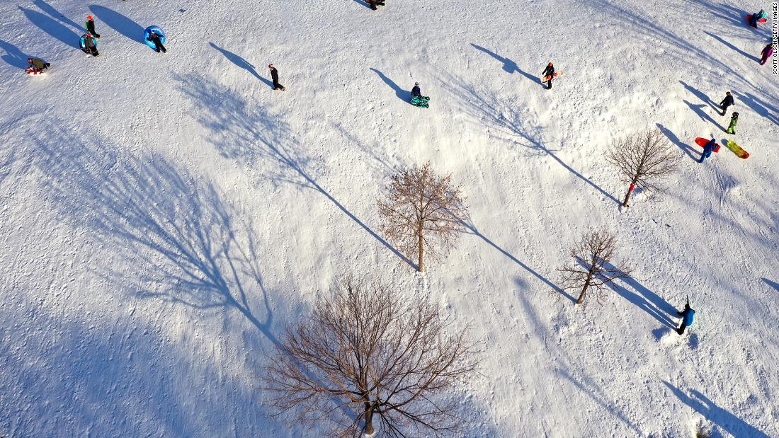 Sledders walk up a hill in Chicago&#39;s Humboldt Park on Monday.