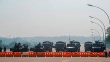 Myanmar & # 39; s military stand guard at a checkpoint manned with armored vehicles blocking a road leading to the parliament building on Febuary 2, 2021, in Naypyidaw, Myanmar. 