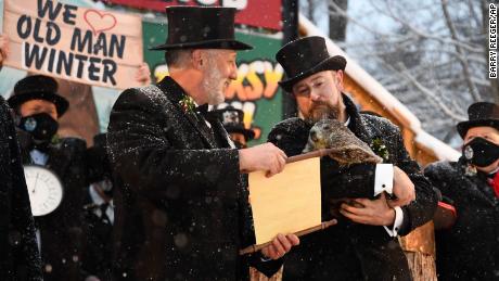 Groundhog Club manager AJ Dereume holds Punxsutawney Phil, the weather forecasting groundhog, while Vice President Tom Dunkel reads the scroll at the 135th Groundhog Day celebration on the Gobbler Button in Punxsutawney.