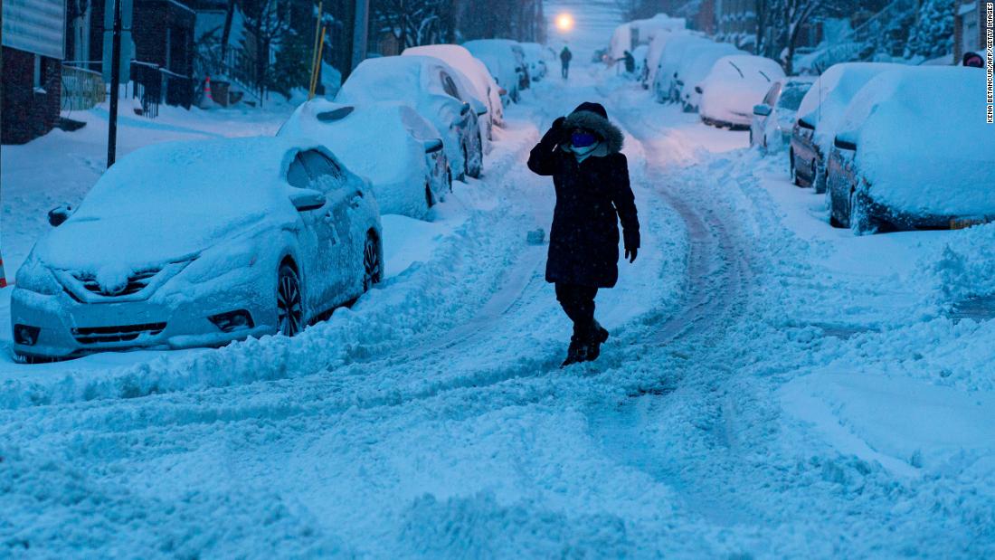 A woman walks on a snowy street in North Bergen, New Jersey, on Monday.