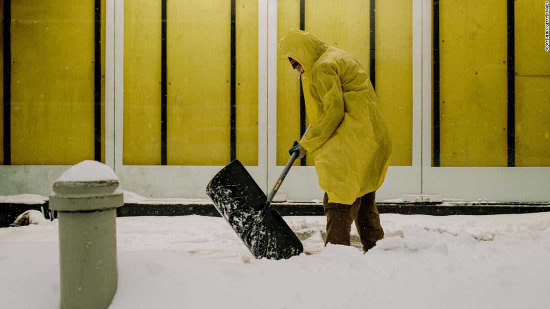 A man shovels snow off a sidewalk in Manhattan on Monday.