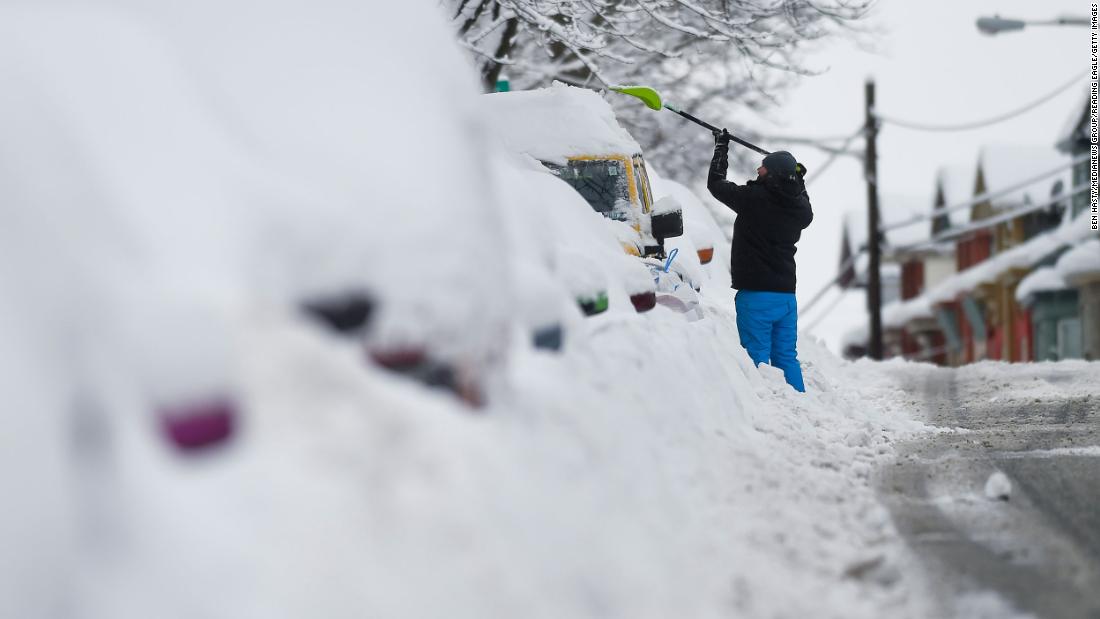 A man clears snow off his car in West Reading, Pennsylvania, on Tuesday, February 2.