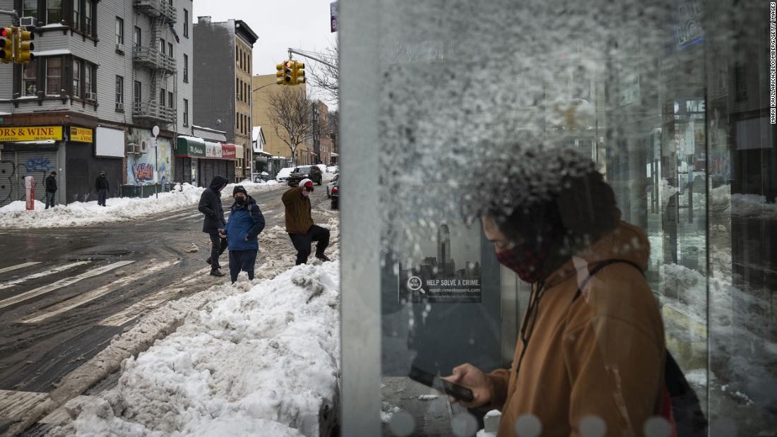 A commuter waits at a bus stop in Brooklyn, New York, on Tuesday.