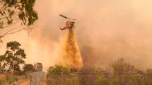 A helicopter drops fire retardant on a fire near Wooroloo, northeast of Perth, Australia, on February 2, 2021. 
