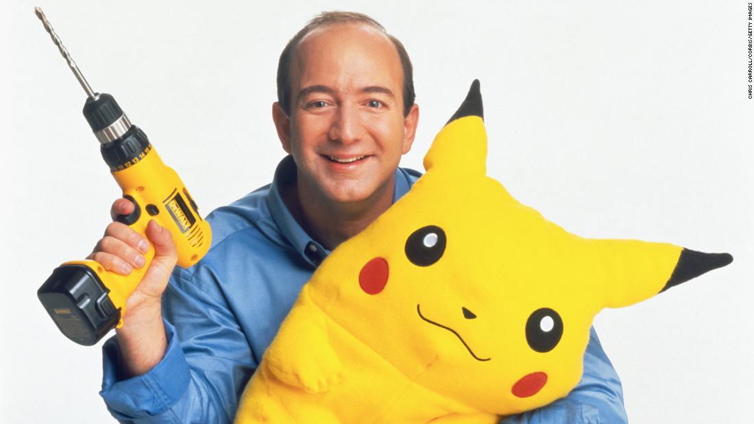 Bezos holds a power drill and a stuffed Pikachu in 1999. By this point, Amazon had started to sell items other than books.