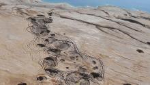 These sinkhole depressions were observed in mud flat sediments near the Dead Sea in Israel.