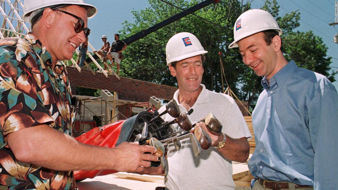 Gregory Nixon, left, delivers a set of antique golf clubs he sold to David Robichaud, center, via Amazon.com Auctions in 1999. Bezos was there for the moment, as Robichaud, a construction worker, was Amazon&#39;s 10-millionth customer.