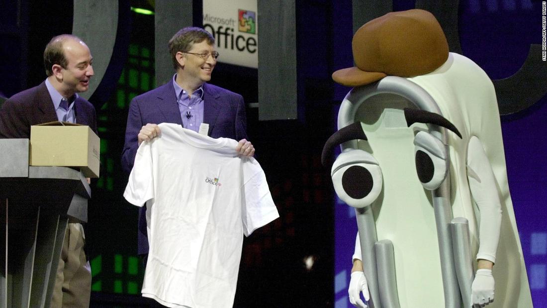 Bezos looks on as Microsoft CEO Bill Gates presents a T-shirt as a retirement gift to Clippy, the Microsoft Office assistant, in 2001. Microsoft was launching Office XP.