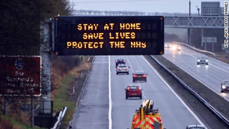Apšviestas greitkelio ženklas su užrašu & quot;  „Lik namuose“ & quot;  Pranešimas, sausio 10 d. Dunfermline, Škotijoje.