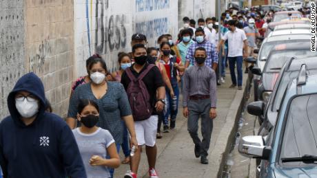 Voters line up outside a polling station during presidential and legislative elections in Guayaquil, Ecuador, Sunday, Feb. 7, 2021. 