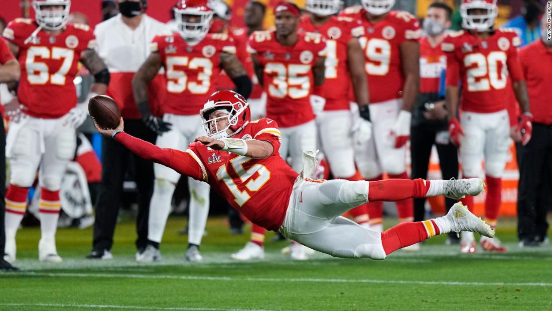 Mahomes attempts a pass while falling down in the second half.