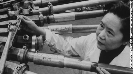 Physicist Chien-Shiung Wu stands beside a particle accelerator at Columbia University, where she worked for decades.