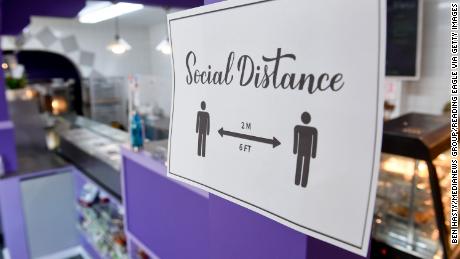 At the Marisol Bakery and Cafe in Pennsylvania, a sign asks people to move away socially on October 6, 2020. Some Americans see returning to life as normal now a moderate-level risk, according to a new poll.