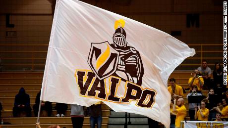 A Valparaiso University cheerleader waves a Valparaiso Crusaders flag.