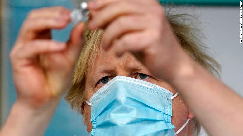 Boris Johnson holds a vial of the Pfizer/BioNTech vaccine as he visits a Covid-19 vaccination centre in Batley, northern England on February 1, 2021. 