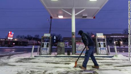 Kirk Caudill shovels away snow from the storm at Pruitt&#39;s Auto Service, in St. Matthews, Kentucky.