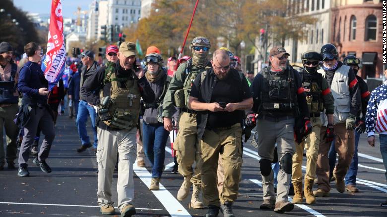 Rhodes, center in eye patch, marches with Oath Keepers through Washington, DC last November. Watkins is visible behind him to his right, wearing jeans and goggles on her ballistic helmet. 