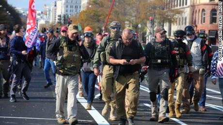 Rhodes, center in eye patch, marches with Oath Keepers through Washington, DC last November. Watkins is visible behind him to his right, wearing jeans and goggles on her ballistic helmet. 