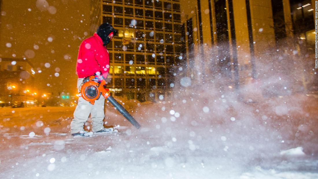 A city employee clears sidewalks in South Bend, Indiana, on Monday.