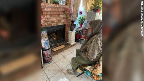 Barbara Martinez's father sits in front of the fireplace at her home in a Houston suburb.