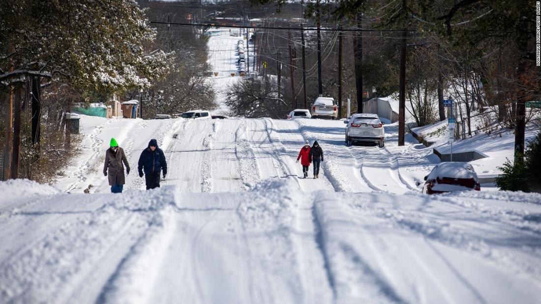 Pedestrians walk on an icy road on Monday, February 15, in East Austin, Texas. 