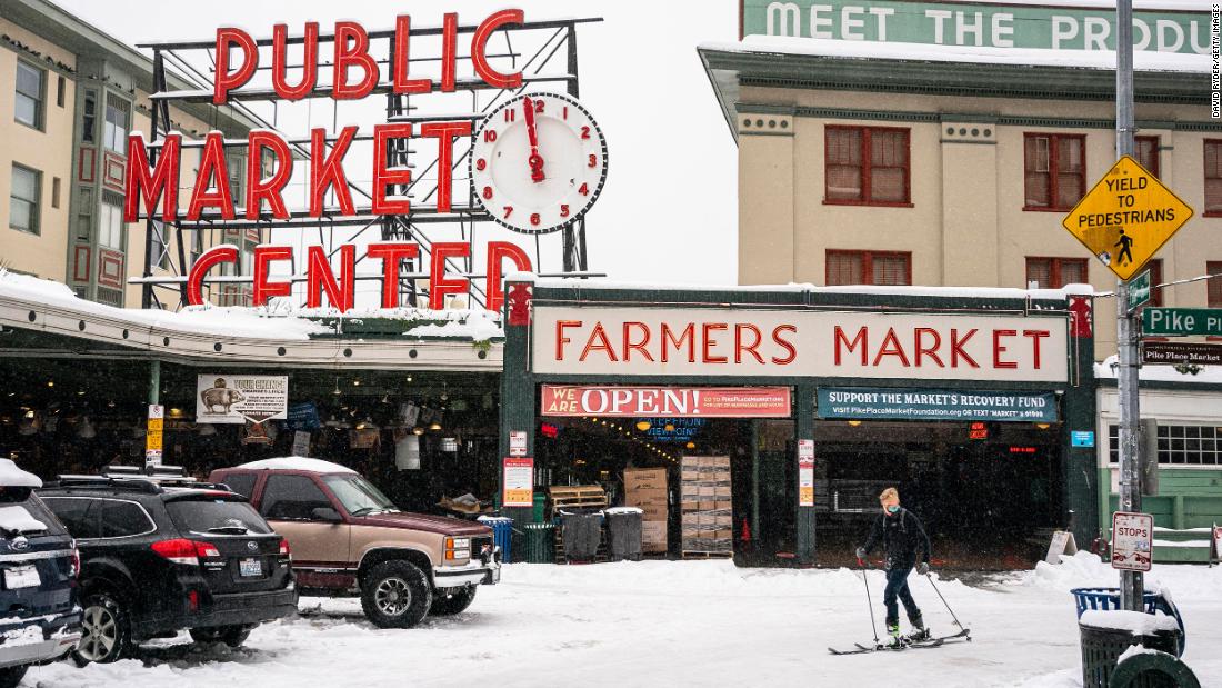 Harrison Walsh skis by Seattle&#39;s Pike Place Market on Saturday.