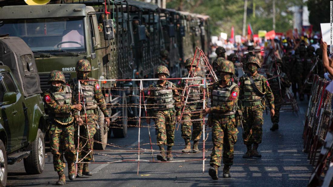 Soldiers carry barricades in Yangon on February 15.