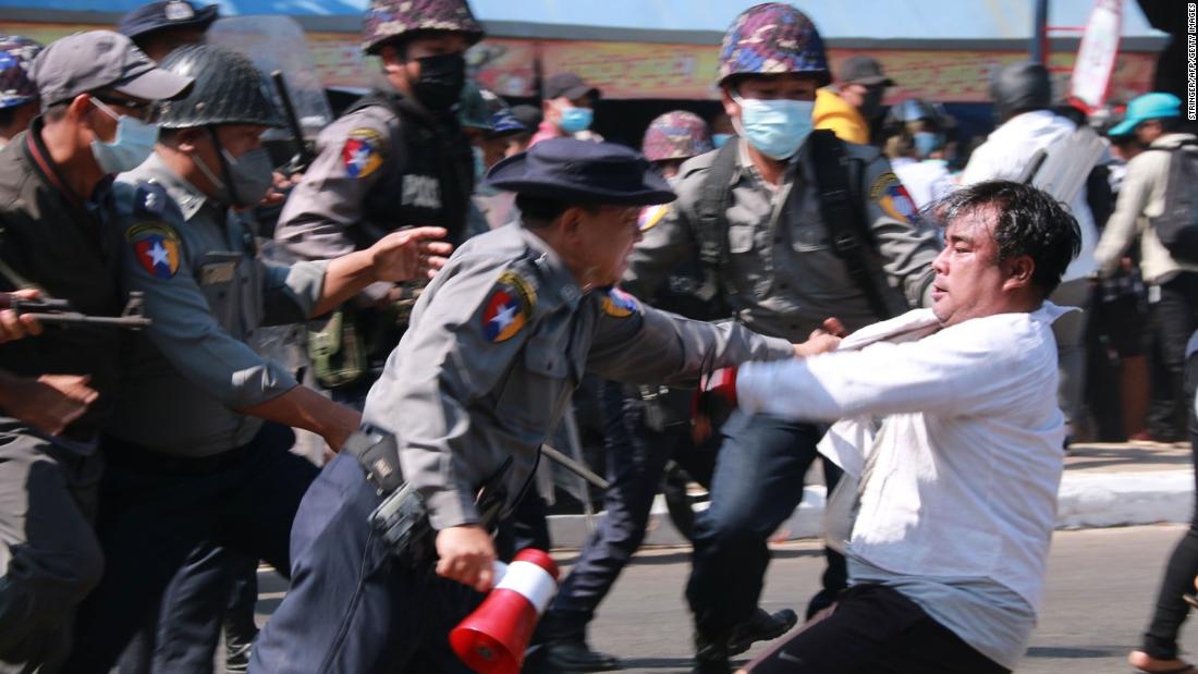 Police detain a protester during a demonstration in Mawlamyine on February 12.