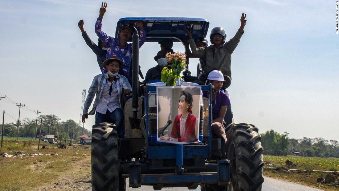 Farmers ride a tractor with a Suu Kyi poster during a demonstration in Thongwa on February 12.