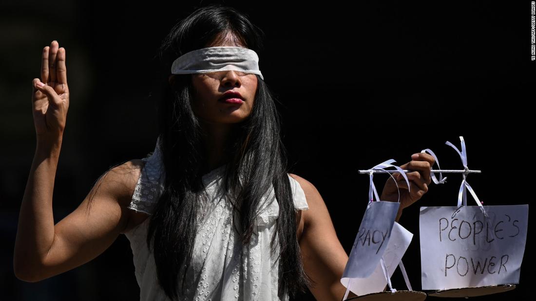 A protester dressed as Lady Justice makes a three-finger salute as she takes part in a demonstration in Yangon on February 11.